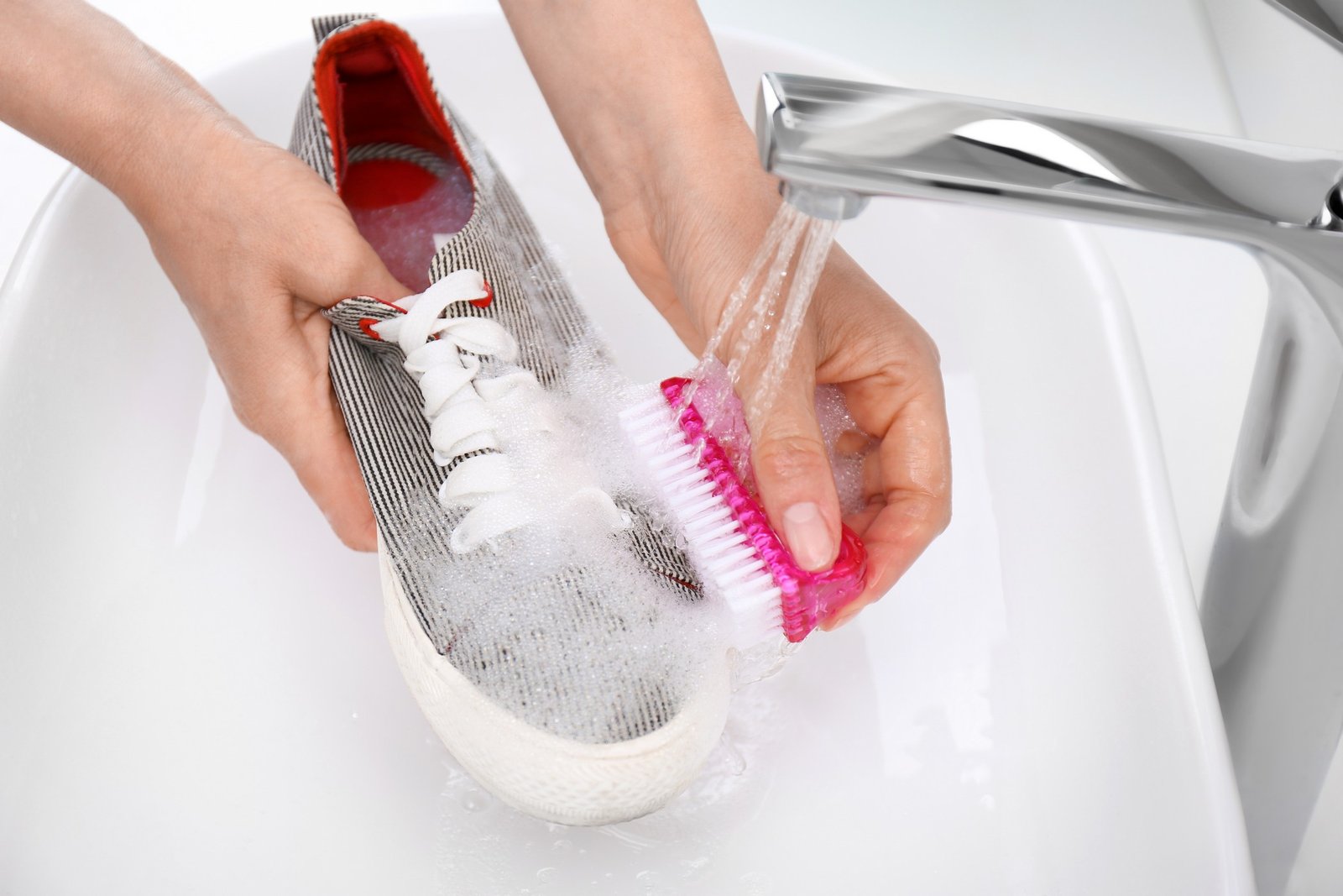 Sportschuhe werden mit einer Bürste gereinigt